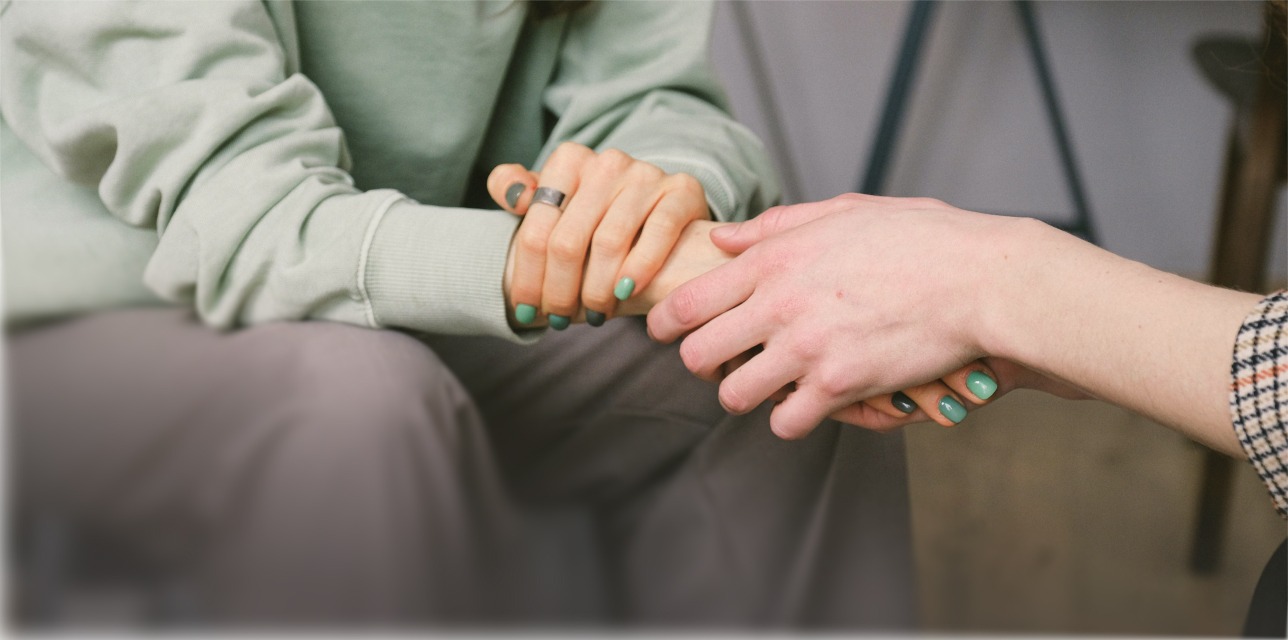 person in green having their hand held by someone else