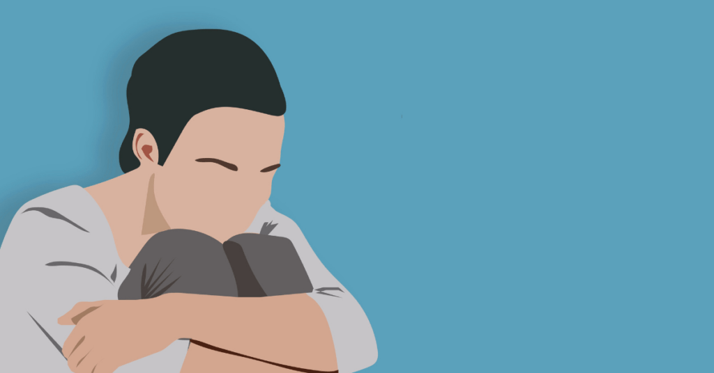 Person sitting with knees pulled in, holding phone