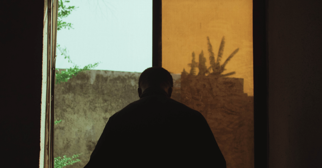 Silhouette of man in front of an orange and clear glass window