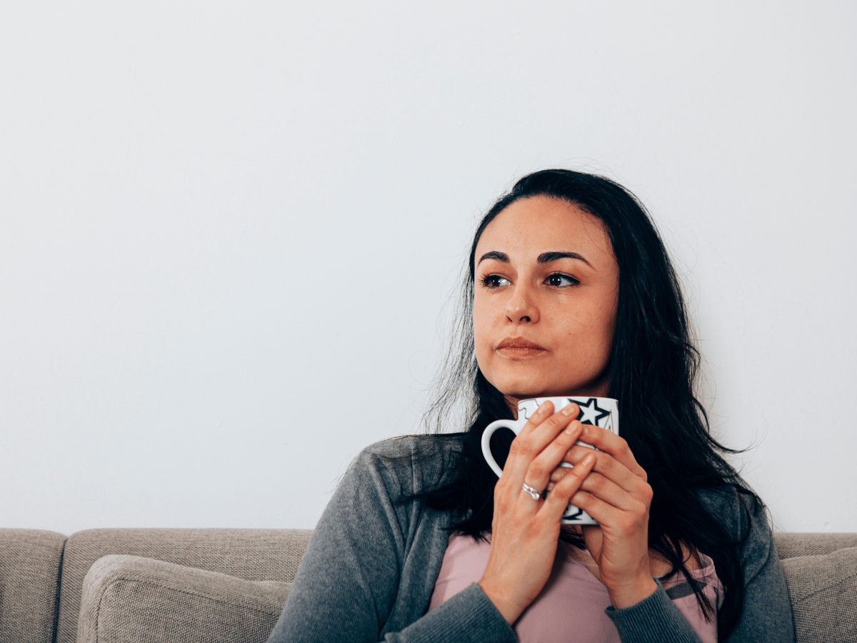 woman sitting on a couch holding a coffee cup with star details