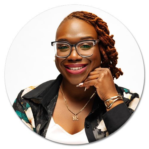 Professional headshot of Monique Overstreet, MA, LPC, smiling and resting her chin on her hand while wearing glasses.